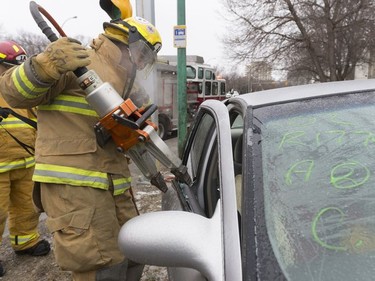 Regina Fire and Protection Services uses the Jaws of Life to pry off a car door.