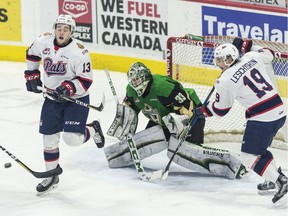 Regina Pats forwards Jared Legien, left, and Jake Leschyshyn try for a deflection on Prince Albert Raiders goalie Ian Scott on Sunday at the Brandt Centre.