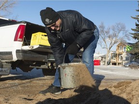 George Biletski scoops some sand into his truck at the Al Ritchie Arena. In reaction to the slippery conditions, the City of Regina made free sand available for public use to keep sidewalks and driveways safe.