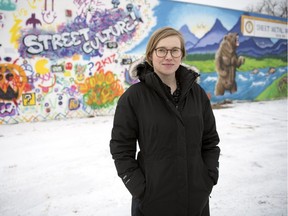 Shayna Stock, Executive Director of the Heritage Community Association, stands out front of some murals in Regina.