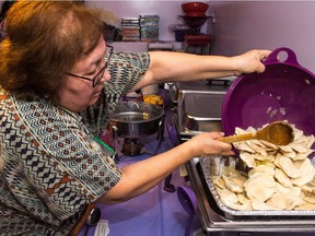 Frieda LeVasseur pours some cheese and potato perogies into a serving dish at the home of Barb Dedi where a massive Ukrainian Christmas feast was about to get underway.