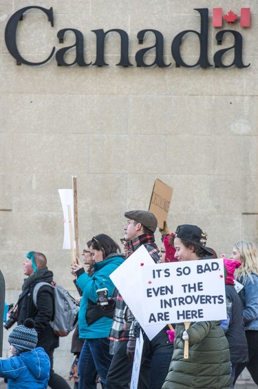 Participants in the Women's March Regina walk along Victoria Avenue in front of a federal government building on Jan. 20, 2018.