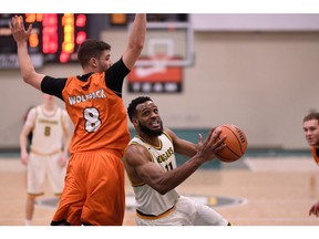 Brian Ofori, right, of the University of Regina Cougars drives to the basket Thursday against the visiting Thompson Rivers University WolfPack.