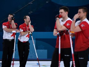 TOPSHOT - Canada's Ben Hebert (L)and Brent Laing (2nd L)look on during the curling men's round robin session between Canada and Sweden during the Pyeongchang 2018 Winter Olympic Games at the Gangneung Curling Centre in Gangneung on February 17, 2018.