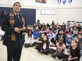 Sgt. Craig M. Smith, an RCMP officer from Nova Scotia, talks to children about Black History Month at Ecole St. Mary in Regina.