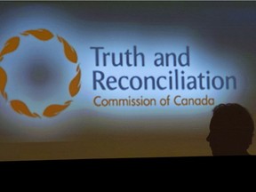 A woman walks past a sign during the second day of closing events for the Truth and Reconciliation Commission in Ottawa, Monday June 1, 2015.
