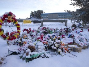 The sun rises over a memorial La Loche Community School, the site of a deadly shooting last month.