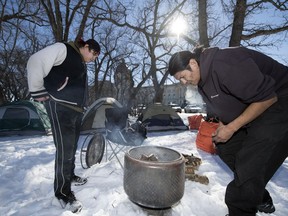 James Dubois (left) and Prescott Demas start a fire at a camp on the grounds near the Legislative Building in Regina.