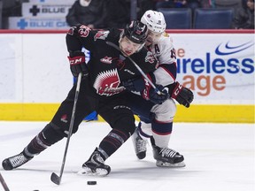 Regina Pats centre Jake Leschyshyn battles to take the puck away from Moose Jaw Warriors forward Tristin Langan during WHL action at the Brandt Centre on Wednesday.