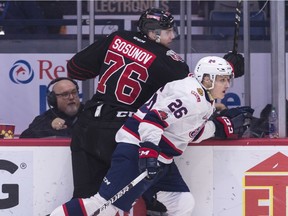 Bryce Platt (26) of the Regina Pats checks Oleg Sosunov of the Moose Jaw Warriors along the boards during WHL action at the Brandt Centre on Wednesday.