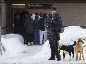 An RCMP officer stands outside the courthouse in La Loche, Sask. Reporters were locked outside for more than an hour Friday morning.