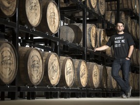 Last Mountain Distillery's production manager Braeden Raiwet stands by some barrels in Lumsden.
