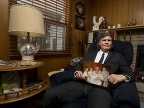 Gord Young, whose family opened Canada's second KFC franchise in Saskatoon 63 years ago, holds a photo of himself and other family members with Col. Harland Sanders.