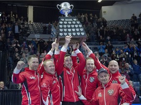 Team Canada skip Brad Gushue, third Mark Nichols, second Brett Gallant, lead Geoff Walker, coach Jules Owchar and alternate Tom Sallows, left to right, hold the Brier Tankard after defeating Alberta 6-4 to win the Canadian men's curling championship Sunday at the Brandt Centre.