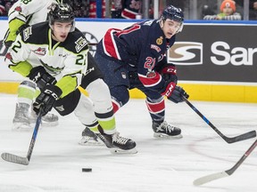 Mathew Robertson of the Edmonton Oil Kings, attempts a backhanded shot while avoiding Nick Henry of the Regina Pats at Rogers Place in Edmonton on Sunday.