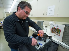 Retired teacher and principal Jamie Bresciani plays a Miller Rovers album from 1968 at  Miller High School in Regina.