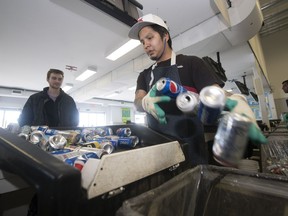 Ezra Maxie, recycling technician employed by Sarcan, sorts the drop-off of Zack Hubelit in Regina.