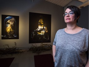 Artist Laura St. Pierre poses for a portrait next to some of her work in an exhibition called Museum of Future History on display at the Regina Public Library Sherwood Branch Gallery in Regina. The photo/instalment exhibition featured plant life suspended in glass containers full of alcohol.