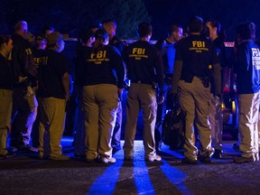 FBI agents meet at the scene of an explosion in Austin, Texas, Sunday, March 18, 2018.