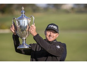 Mackenzie Hughes, of Canada, poses with the trophy after winning the playoff round at the RSM Classic golf tournament, Monday, Nov. 21, 2016, in St. Simons Island, Ga.