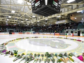 Flowers lie on the ice as people gather for a vigil at the Elgar Petersen Arena, home of the Humboldt Broncos, in Humboldt on April 8. The vigil honoured the victims of the fatal bus-semi crash that occurred at a rural intersection near Tisdale on April 6.