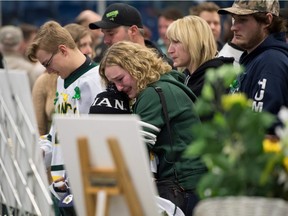 Mourners comfort each other during a vigil at the Elgar Petersen Arena, home of the Humboldt Broncos, to honour the victims of a fatal bus accident, April 8, 2018 in Humboldt, Canada. Mourners in the tiny Canadian town of Humboldt, still struggling to make sense of a devastating tragedy, prepared Sunday for a prayer vigil to honor the victims of the truck-bus crash that killed 15 of their own and shook North American ice hockey.