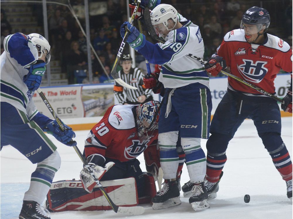 Saskatoon Blades' goalie Logan Flodell, right, makes a save