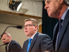 Premier Scott Moe, centre, speaks about the Saskatchewan government's position on a federally imposed carbon tax at the provincial Legislative Building while flanked by Minister of Environment Dustin Duncan, left,  and Attorney General Don Morgan.