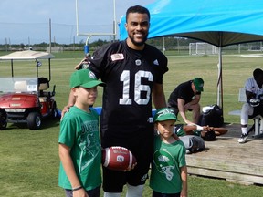 Saskatchewan Roughriders quarterback Brandon Bridge (16) made friends with Riders fans Stephen (left) and Peter Novecosky on Tuesday with a game of catch.