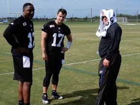 Saskatchewan Roughriders quarterbacks Marquise Williams (left) and Zach Collaros and head coach Chris Jones take a break during Tuesday's session at the CFL's mini-camp in Bradenton, Fla.