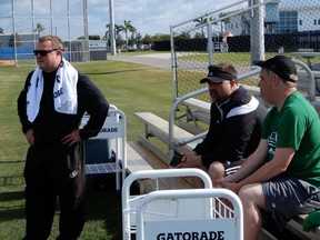 Saskatchewan Roughriders head coach and general manager Chris Jones (left) and assistant vice-president of football operations and administration Jeremy O'Day (centre) and assistant vice-president of football operations and player personnel John Murphy watch Tuesday's practice at the CFL team's mini-camp in Bradenton, Fla.