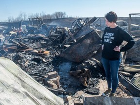 April 27, 2018  -- Tiffany Schaefer looks over remains of a garage and its contents on her property south of Lumsden, Saskatchewan following a grass fire in the area. As she was looking at the smouldering heap, she was recalling all the things she'd stored in the building.
