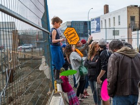 People gather along the fence at the Capital Pointe construction site at the intersection of Albert Street and Victoria Avenue in Regina where they were preparing to say "Wow," at the hole, emulating actor Owen Wilson.