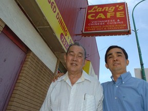 Tran Van Minh (right) and his father Tran Jan Lang proudly stand in front of Lang's Cafe on Broad Street, which was the first of nine Vietnamese restaurants family members started.