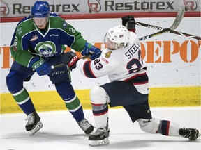 Swift Current Broncos defenceman Colby Sissons, left, and Regina Pats captain Sam Steel get tied up in Game 6 of a WHL first-round playoff series.