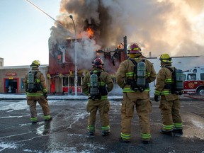 Firefighters work as Lang's Café on Broad Street burns.