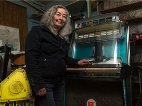 Dorothy Stuart, owner of the Wonderland arcade on Broad Street, stands next to a vintage "Rock-Ola" jukebox housed in the business.