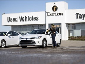 Kelsey Brown, lot attendant at the Taylor Toyota used vehicle lot in Regina, wipes down a freshly washed used 2016 Toyota Avalon. The province is eliminating a provincial sales tax (PST) exemption for the sale of used vehicles, although it will retain an exemption for vehicles sold privately under $5,000 or vehicles sold to family members.