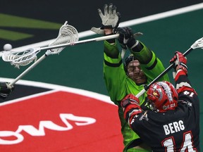 Saskatchewan Rush Ryan Dilks blocks a shot from Calgary Roughnecks' Wesley Berg during a one-game, sudden-death playoff game at SaskTel Centre in Saskatoon on May 13, 2018.