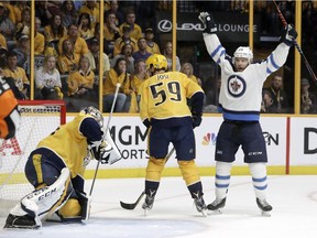 Winnipeg Jets center Paul Stastny, right, celebrates after teammate Tyler Myers, not shown, scored a goal against Nashville Predators goalie Pekka Rinne, left, of Finland, during the first period in Game 7 of an NHL hockey second-round playoff series Thursday, May 10, 2018, in Nashville, Tenn. Also defending for the Predators is Roman Josi (59), of Switzerland.