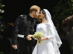 Prince Harry and Meghan Markle kiss on the steps of St George's Chapel in Windsor Castle after their wedding in Windsor, near London, England, Saturday, May 19, 2018.