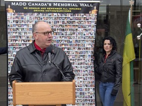 Wayne Nichols, president of the newly formed MADD Regina Chapter, speaks as Alyscia Kaufmann helps hold a memorial sign at City Hall during an event promoting Campaign 9-1-1, which encourages people to call 9-1-1 if they see an impaired driver.