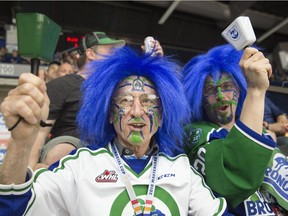 Swift Current Broncos  fans Ray McGregor, left, and Preston Lord ring their cowbells during the 100th-anniversary Memorial Cup at the Brandt Centre.