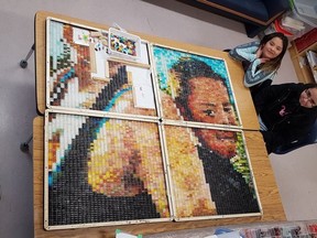 Natalia Wolverine, 24, and her little brother Jarome, 10, died in a house fire in Patuanak, Sask. on Jan. 18, 2015. Michele Mackasey, an artist-in-residence in Patuanak, is leading a community project to make a portrait of the two out of hundreds of little glass bottles filled with coloured liquid. Ryanne Apesis (left) and Kala Drabinasty (right), students at St Louis School in Patuanak, pose for a photo with the work-in-progress. Photo submitted by Michele Mackasey.