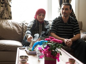 Abd Elkarim Elaiwy, right, and Rawda Al Khalifa sit in the living room of their home in Regina. The husband and wife spent time living in a Lebanese refugee camp with their children before coming to Canada.