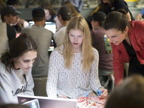 Federal Science Minister Kirsty Duncan observes a science experiment conducted by Martin Collegiate Grade 9 science class students Sadie Rabiej, left, and Hilary Dzioba at the Saskatchewan Science Centre in Regina on Monday.
