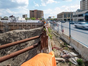 Vehicles speed by a massive hole in the ground where the Capital Pointe development was supposed to take shape on the corner of Albert Street and Victoria Avenue.