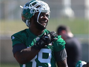 Charleston Hughes chats with a teammate during the Riders' training camp.