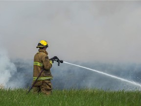 REGINA, SASK : June 20, 2018  -- A firefighter battles a grass fire northeast of the Co-op refinery in Regina. BRANDON HARDER/ Regina Leader-Post