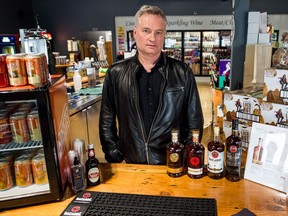 Allen Kilback, owner of the Happy Hour liquor store in Pilot Butte, stands at the store's bar.